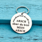 Preview: Runder Metall Schlüsselanhänger mit Gravur "Manchmal bist du echt ein Arsch aber du bist mein Arsch"
