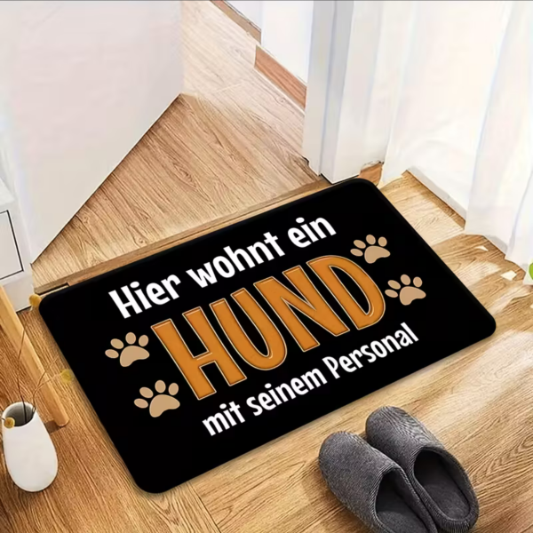 Schwarze Fußmatte Hier wohnt ein Hund mit seinem Personal